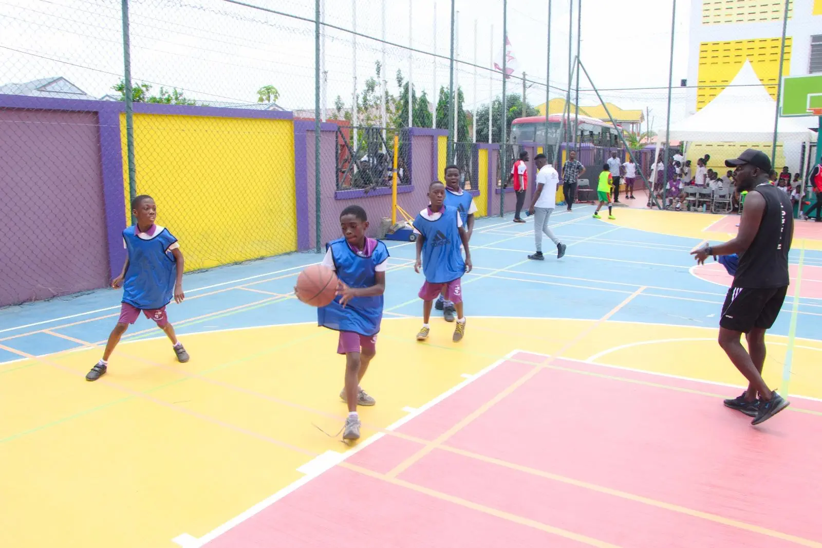 HABIS pupils practising basketball with a coach on the school court