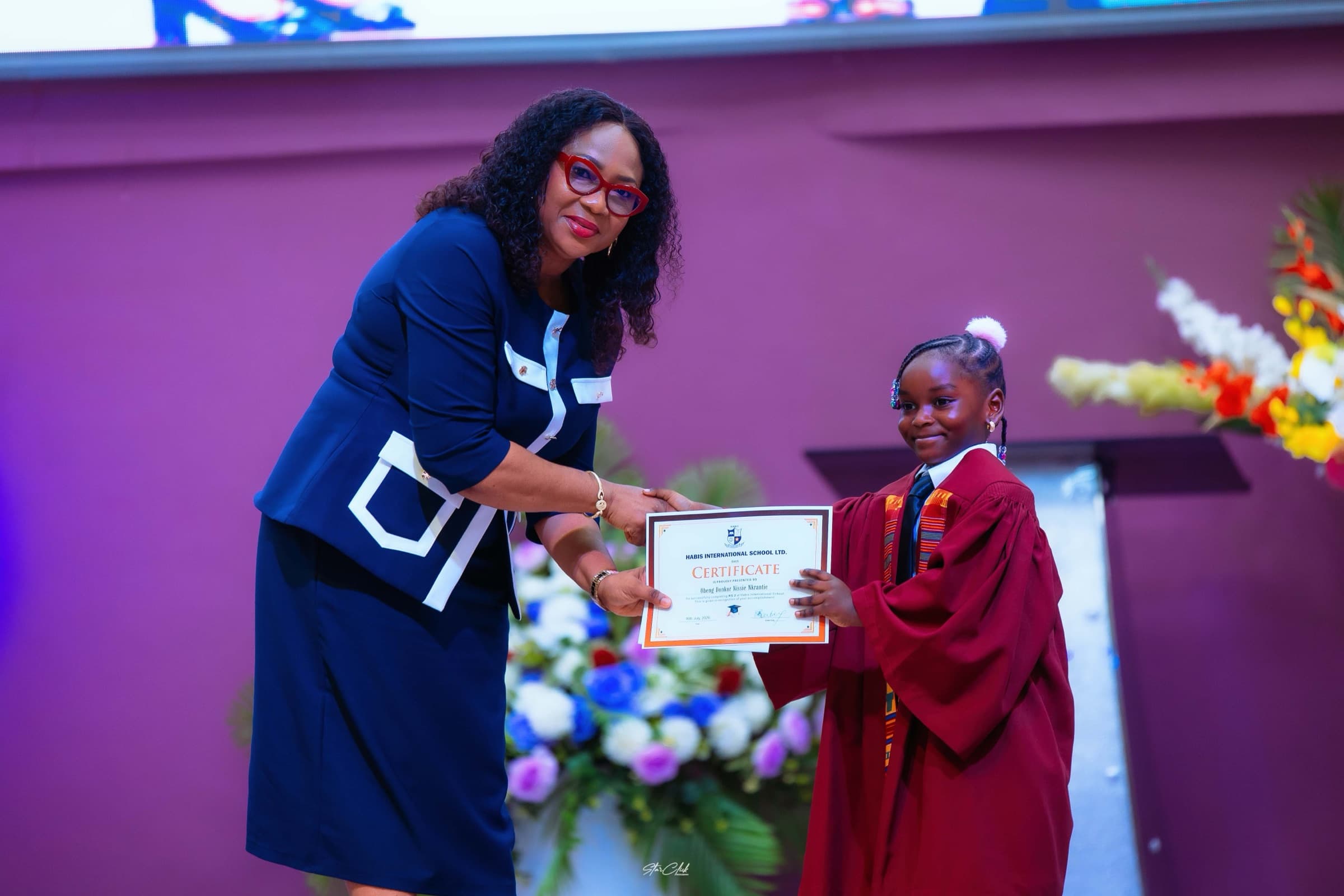 A young HABIS graduate holding her certificate