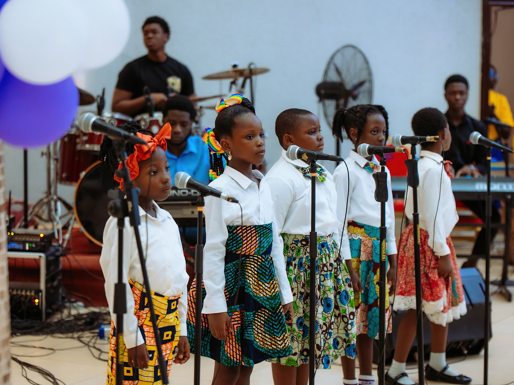 Young HABIS pupils singing together at microphones