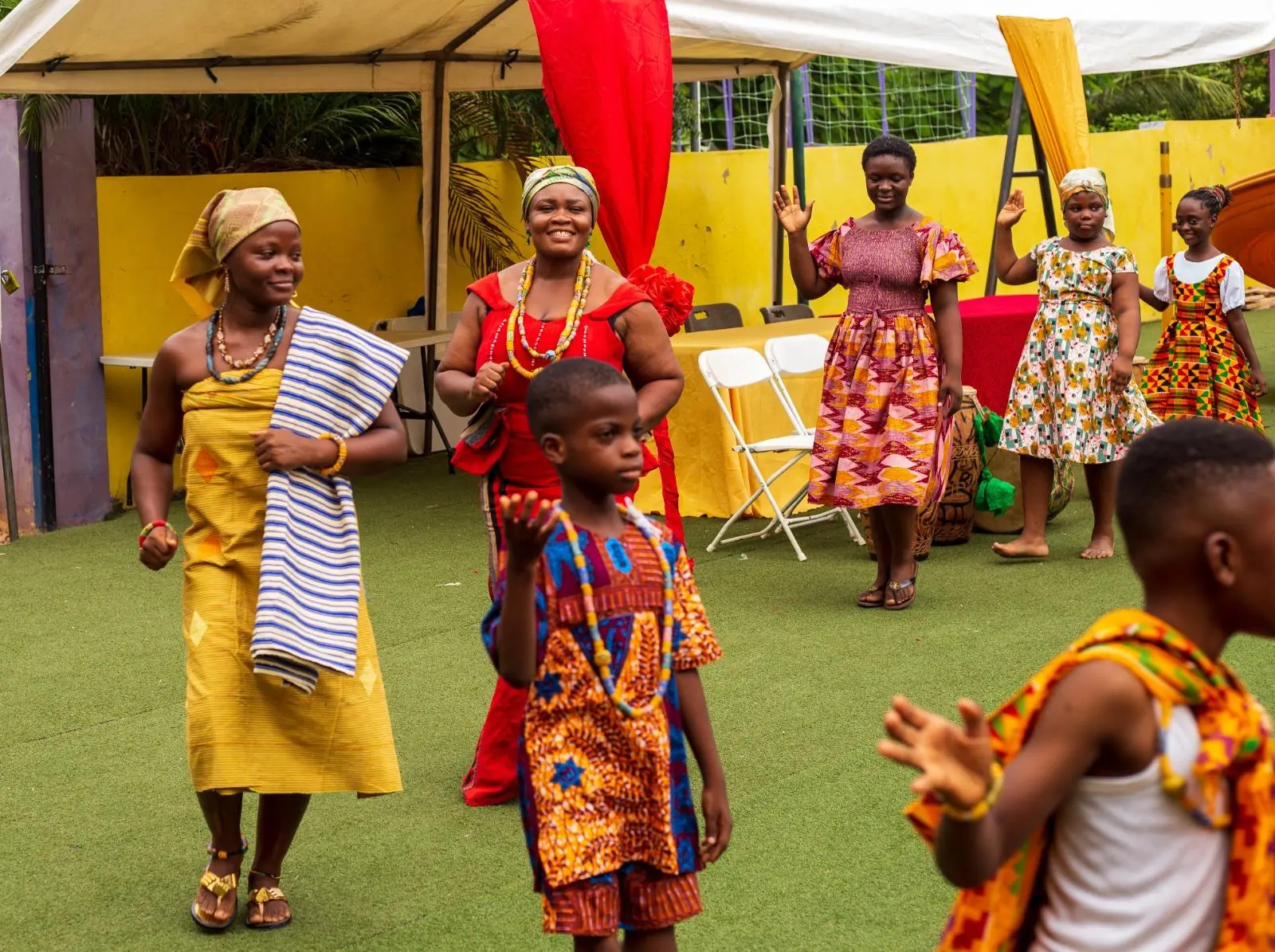 Pupils and adults wearing colourful traditional clothing on the school field